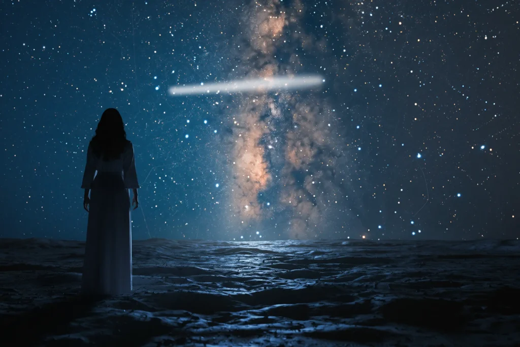 Silueta de una figura humana de pie sobre un terreno oscuro, observando un cielo nocturno lleno de estrellas y la Vía Láctea, con una franja luminosa horizontal que sugiere misterio y reflexión sobre el origen de lo no terrestre.